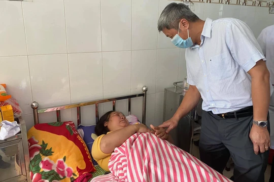 Thứ trưởng Bộ Y tế Nguyễn Trường Sơn thăm hỏi nạn nhân trong vụ sạt lở đất ở Trà Leng (Ảnh: Vũ Mạnh Cường) 