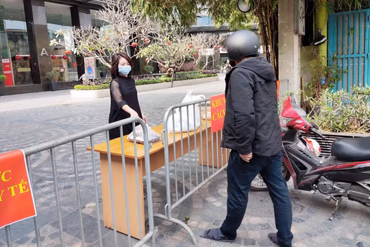 Người dân lấy đồ từ bên trong khu cách ly ở chung cư Sky City Tower (Ảnh - Minh Thuý) 