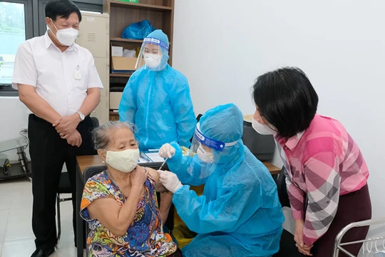 Thứ trưởng Bộ Y tế Đỗ Xuân Tuyên kiểm tra việc tiêm vaccie COVID-19 cho người dân (Ảnh - Trần Minh)