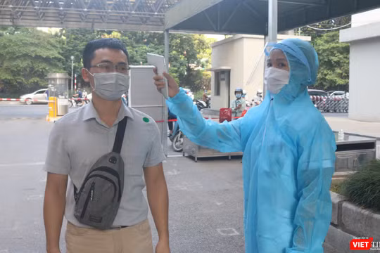 Người dân được kiểm tra nhiệt độ trước khi vào bệnh viện (Ảnh - Minh Thuý) 