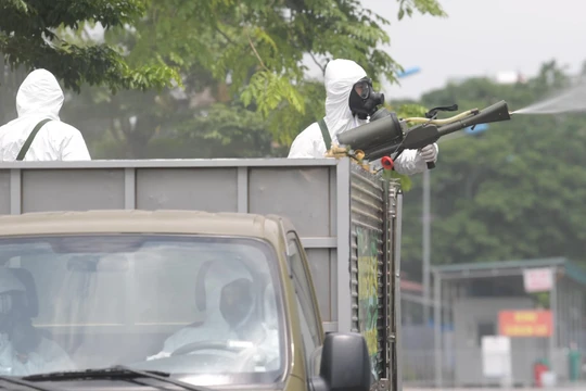 Nhân viên y tế phun khử khuẩn (Ảnh - Hoàng Anh)