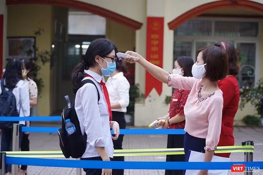 Giáo viên đo nhiệt độ cho học sinh (Ảnh - Minh Thuý) 