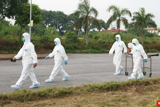 Nhân viên y tế chuẩn bị phun khử khuẩn phòng COVID-19 (Ảnh - Minh Thuý) 