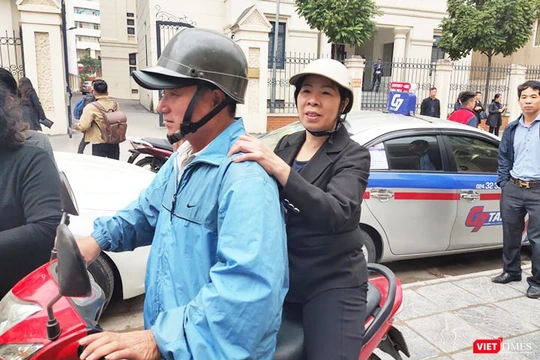 Bị cáo Nguyễn Bích Quy (áo đen đội mũ bảo hiểm ngồi sau) ra về sau khi phiên tòa kết thúc. Ảnh: Minh Thúy. 