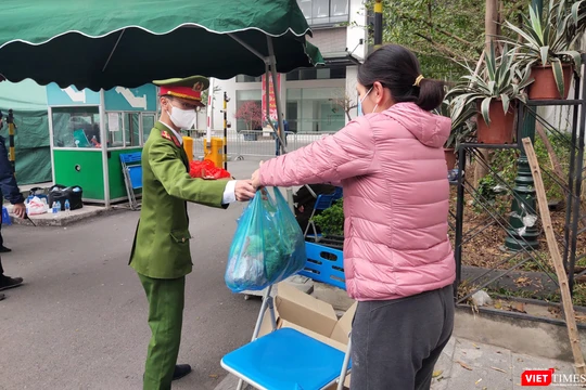 Người dân gửi thực phẩm vào bên trong khu vực phong toả vì COVID-19 (Ảnh - Minh Thuý) 