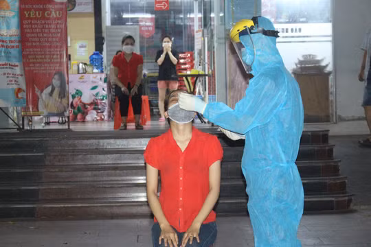 Nhân viên y tế lấy mẫu xét nghiệm COVID-19 cho người dân (Ảnh - LT) 