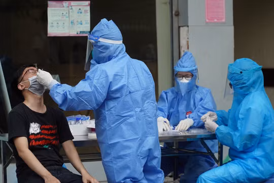 Nhân viên y tế lấy mẫu xét nghiệm COVID-19 cho người dân (Ảnh - Minh Nhân) 