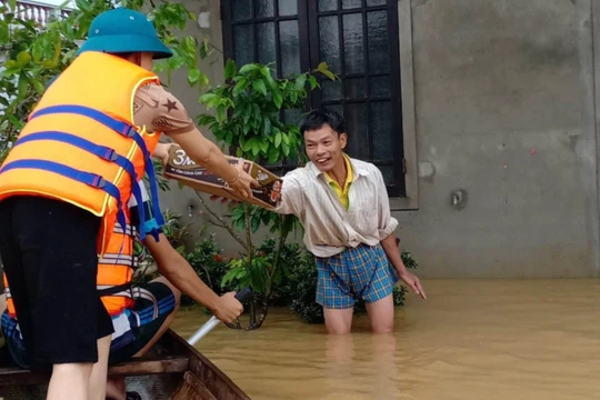 Cứu trợ gia đình người dân bị ngập sâu (Ảnh: Hoàng Triều - nguồn: baothuathienhue.vn) 