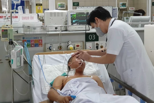 TS.BS. Nguyễn Tiến Dũng - Trung tâm Chống độc, Bệnh viện Bạch Mai khám bệnh cho một bệnh nhân ngộ độc methanol (Ảnh: Mai Thanh) 