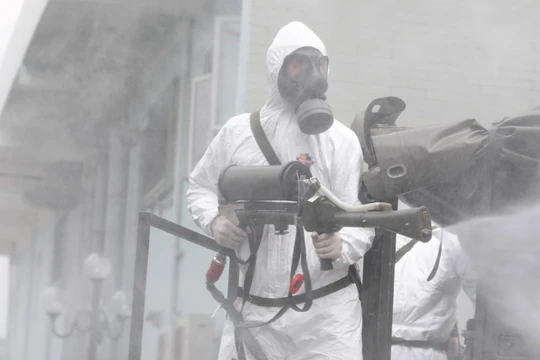 Nhân viên y tế phun khử khuẩn phòng dịch COVID-19 (Ảnh - Hoàng Anh) 