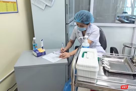 Bác sĩ ghi nhật ký tiêm chủng (Ảnh: Minh Thúy)