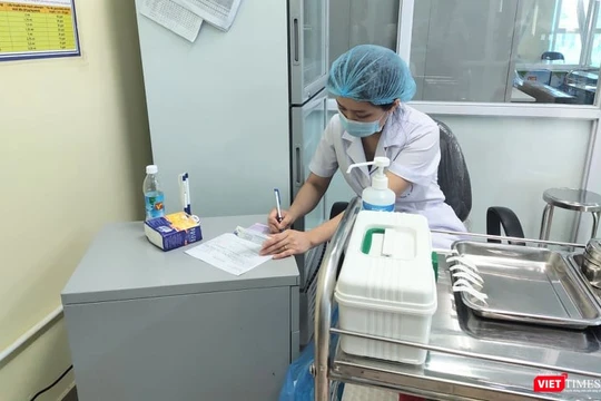 Bác sĩ ghi nhật ký tiêm chủng (Ảnh: Minh Thúy)
