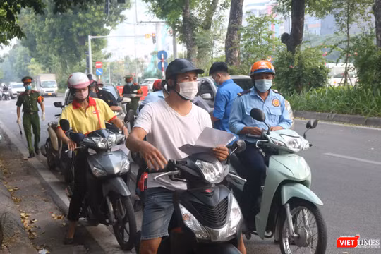 Người dân xếp hàng chờ kiểm tra giấy đi đường (Ảnh - Minh Thuý) 