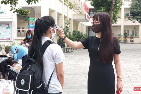 Cô giáo đo nhiệt độ cho học sinh (Ảnh- Minh Thuý) 
