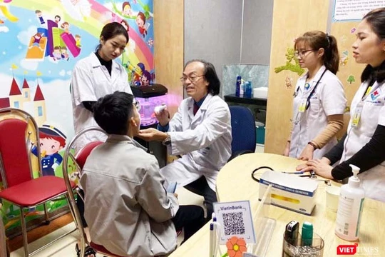 PGS. TS. Nguyễn Tiến Dũng thăm khám cho bệnh nhi. Ảnh: Thanh Hằng 