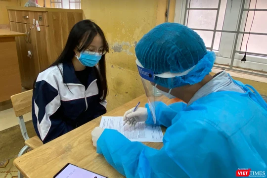 Bác sĩ kiểm tra sức khoẻ của học sinh trước khi tiêm vaccine COVID-19 (Ảnh - Minh Thuý) 