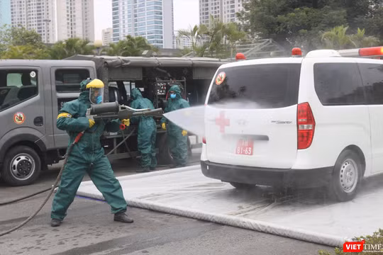 Nhân viên y tế diễn tập phun khử khuẩn (Ảnh - Minh Thuý) 