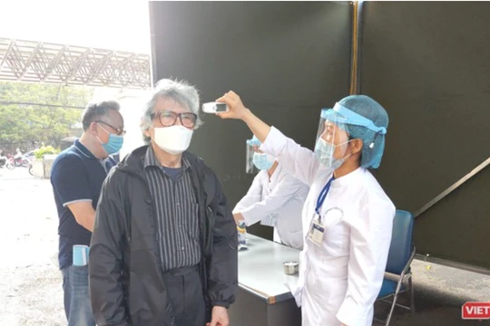 Nhân viên y tế kiểm tra nhiệt độ cho người dân (Ảnh - Minh Thuý) 