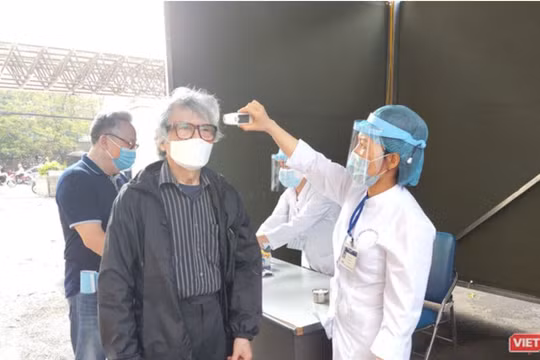 Nhân viên y tế kiểm tra nhiệt độ cho người dân (Ảnh - Minh Thuý) 