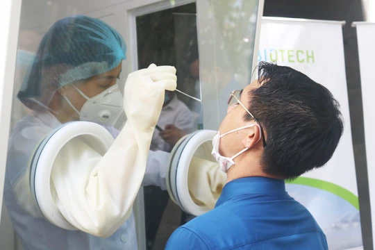 Nhân viên y tế trực tiếp thực hiện thử nghiệm việc lấy mẫu xét nghiệm COVID-19 tại bốt lấy mẫu xét nghiệm di động (Ảnh - Minh Thuý) 