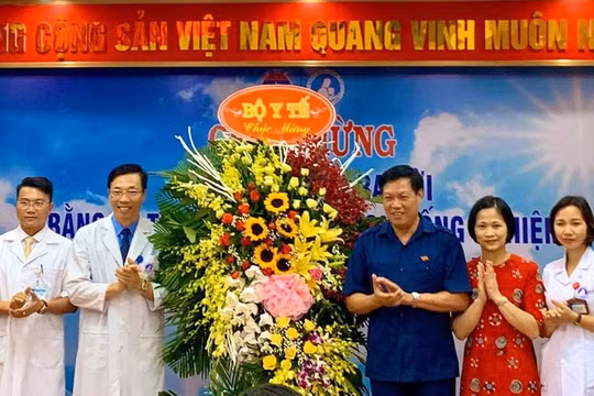 Thứ trưởng Bộ Y tế Đỗ Xuân Tuyên (áo xanh) chúc mừng em bé đầu tiên ra đời bằng kỹ thuật thụ tinh trong ống nghiệm. (Ảnh: Thảo Nguyên)