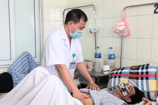 BS. Hưng khám cho bệnh nhân viêm màng não (Ảnh - Minh Thuý) 