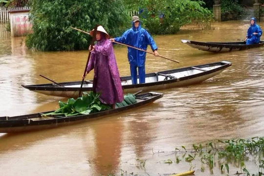 Người dân di chuyển khi thời tiết bão lũ (Ảnh: Hoàng Triều - nguồn: baothuathienhue.vn) 