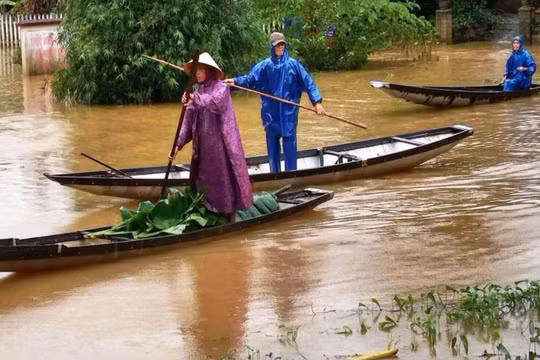 Người dân di chuyển khi thời tiết bão lũ (Ảnh: Hoàng Triều - nguồn: baothuathienhue.vn) 
