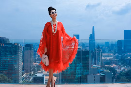 Diễm My diện đầm màu đỏ, phom rộng trên nền chất liệu ren kết hợp chi tiết lông đính kết. Nữ hoàng ảnh lịch vẫn trung thành với kiểu trang điểm, làm tóc cầu kỳ. Ảnh: Trung Tín, Thảo Tiên.