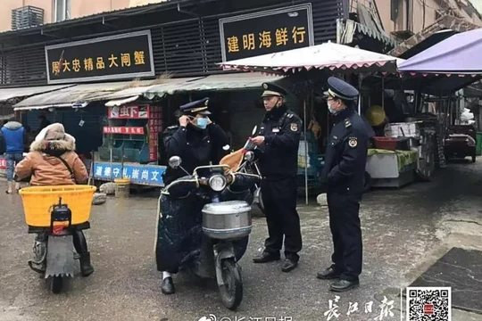 Cảnh sát địa phương canh gác nghiêm ngặt trước chợ hải sản bị đóng cửa ở Vũ Hán do bị nghi ngờ là nguồn lây bệnh viêm phổi lạ (Ảnh: Yangtze Daily - SCMP)