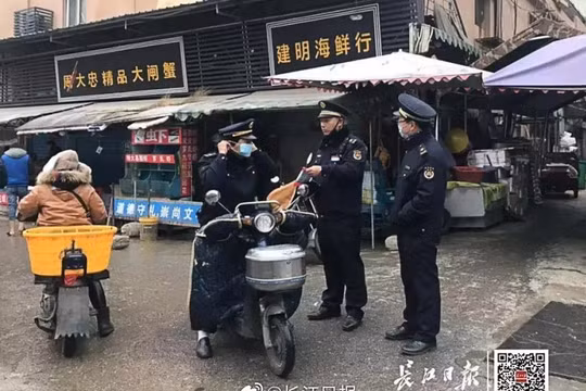 Cảnh sát địa phương canh gác nghiêm ngặt trước chợ hải sản bị đóng cửa ở Vũ Hán do bị nghi ngờ là nguồn lây bệnh viêm phổi lạ (Ảnh: Yangtze Daily - SCMP)