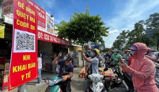 Người dân quét mã khai báo y tế trên điện thoại tại trạm kiểm soát trên đường Nguyễn Kiệm (Gò Vấp) ngày 7/6 (Ảnh: SGGP) 