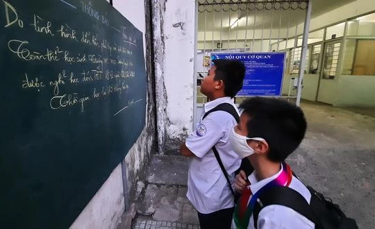 Học sinh Trường THCS - THPT Sương Nguyệt Anh (Q.10, TP.HCM) xem thông báo nghỉ học tránh dịch - Ảnh: Như Hùng 