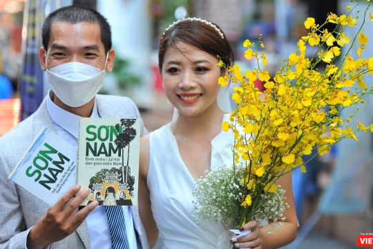 Chú rể Nguyễn Anh Tú và cô dâu Nguyễn Thị Tuyết Mai sung sướng đón nhận những ấn phẩm được gửi tặng. Ảnh: Nguyễn Á