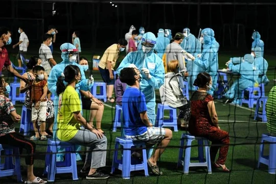 Lấy mẫu xét nghiệm tại một sân banh trên địa bàn phường 15, quận Gò Vấp, trong đêm. Ảnh: Lan Chi