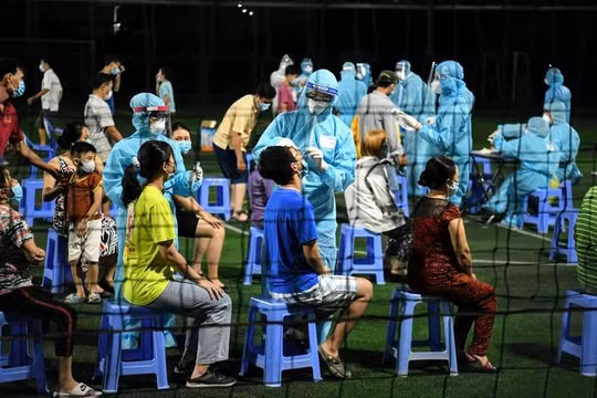 Lấy mẫu xét nghiệm tại một sân banh trên địa bàn phường 15, quận Gò Vấp, trong đêm. Ảnh: Lan Chi