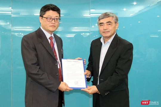 Thứ trưởng Nguyễn Minh Hồng (phải) trao quyết định cho ông Trần Minh. 