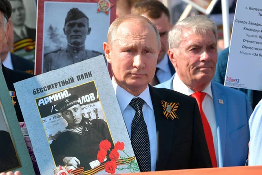 Tổng thống Nga V.Putin mang ảnh người Nga diễu hành cùng với Trung đoàn bất tử nhằm bảo vệ ký ức lịch sử về Ngày Chiến Thắng trong Chiến tranh giữ nước (Ảnh Sputnik)