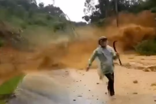 Người đi đường thất thần tháo chạy khỏi đống đất đá từ trên cao đổ xuống (ảnh cắt từ clip)