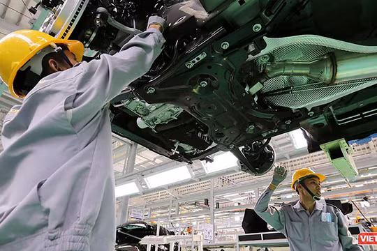 Công nhân làm việc trong phân xưởng lắp ráp ô tô.