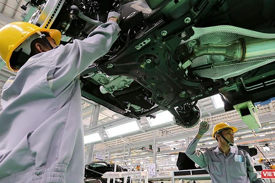 Công nhân làm việc trong phân xưởng lắp ráp ô tô.