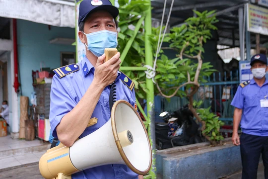 Lực lượng bảo vệ tuyên truyền phòng, chống dịch COVID-19 đối với người dân đi chợ ở Đà Nẵng