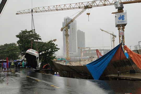 Lực lượng cứu hộ cẩu kéo ô tô bị hố tử thần nuốt chửng.