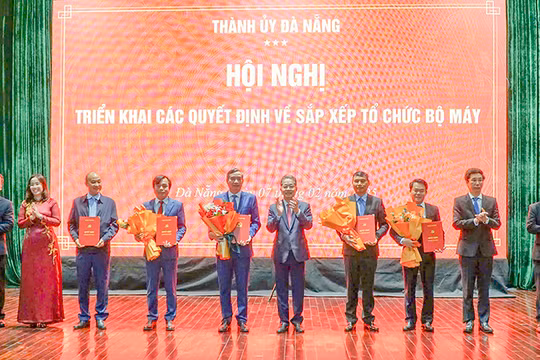 Ông Nguyễn Văn Quảng (thứ 5 từ phải sang), Bí thư Thành ủy Đà Nẵng trao quyết định cho ông Lê Trung Chinh (thứ 5 từ trái sang) và các cá nhân tại hội nghị.