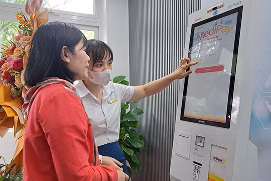 Nhân viên Bệnh viện Đà Nẵng hướng dẫn người bệnh sử dụng Ki-ốt y tế thông minh