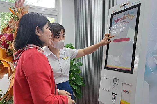 Nhân viên Bệnh viện Đà Nẵng hướng dẫn người bệnh sử dụng Ki-ốt y tế thông minh