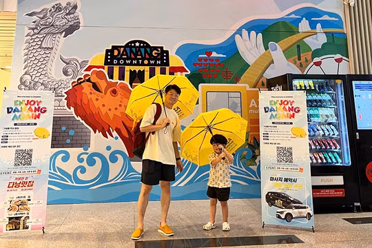 Du khách Hàn Quốc thích thú với chiếc dù có logo, hình ảnh du lịch Đà Nẵng