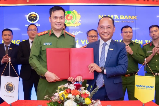 Phó tổng giám đốc Nam A Bank Nguyễn Vĩnh Tuyên (phải) và Thiếu tá Phan Đức Hiệp - Phó Giám đốc Trung tâm RAR ký hợp tác xác thực điện tử qua VNeID.