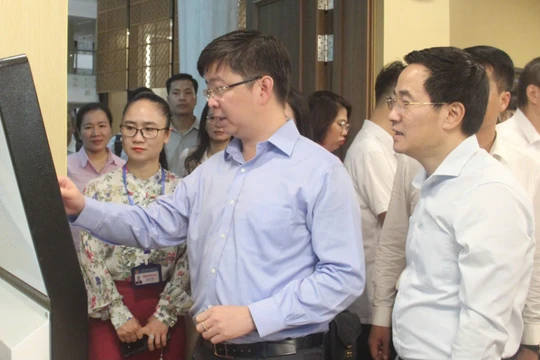 Thứ trưởng Bùi Hoàng Phương thao tác trên thiết bị của Trung tâm Phục vụ hành chính công TP. Hà Nội.