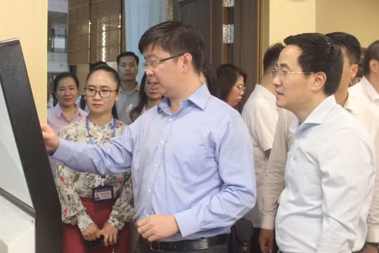 Thứ trưởng Bùi Hoàng Phương thao tác trên thiết bị của Trung tâm Phục vụ hành chính công TP. Hà Nội.